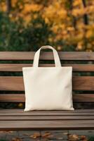 A simple tote bag resting on a wooden bench in a park during autumn photo