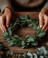 Crafting a beautiful green wreath at a cozy indoor workspace photo