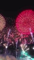 4K. loop seamless of real fireworks background. abstract blur of real golden shining fireworks with bokeh lights in the night sky. glowing fireworks show. video