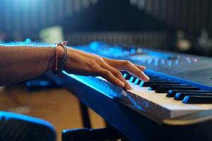 Close up of man's hands playing music keyboard, Asian musician man playing piano and practicing in home studio photo