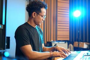 Musician playing music keyboard, Asian man playing piano and practicing in home studio photo