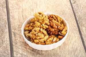 Cracked unshelled walnut in the bowl photo