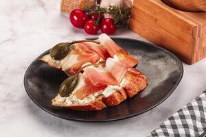 Bruschetta with jamon and caper berries photo