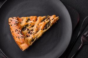 Pieces of quiche with salmon, spinach or broccoli, salt and spices photo