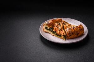 Pieces of quiche with salmon, spinach or broccoli, salt and spices photo