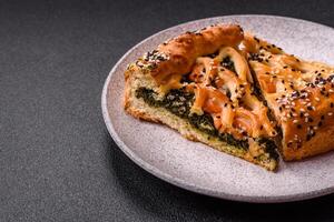 Pieces of quiche with salmon, spinach or broccoli, salt and spices photo