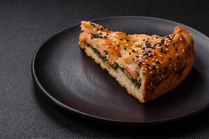 Pieces of quiche with salmon, spinach or broccoli, salt and spices photo