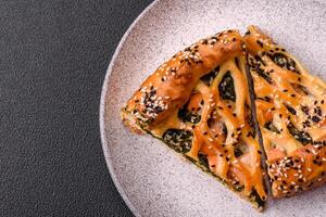 Pieces of quiche with salmon, spinach or broccoli, salt and spices photo