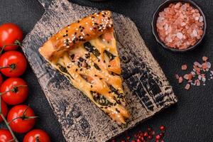 Pieces of quiche with salmon, spinach or broccoli, salt and spices photo