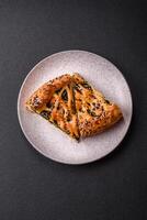 Pieces of quiche with salmon, spinach or broccoli, salt and spices photo