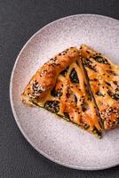 Pieces of quiche with salmon, spinach or broccoli, salt and spices photo
