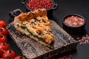 Pieces of quiche with salmon, spinach or broccoli, salt and spices photo
