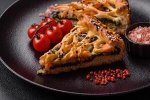 Pieces of quiche with salmon, spinach or broccoli, salt and spices photo