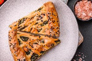 Pieces of quiche with salmon, spinach or broccoli, salt and spices photo