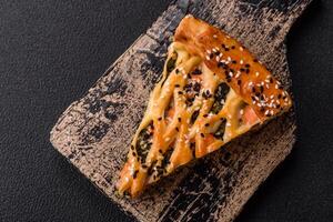 Pieces of quiche with salmon, spinach or broccoli, salt and spices photo