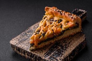Pieces of quiche with salmon, spinach or broccoli, salt and spices photo