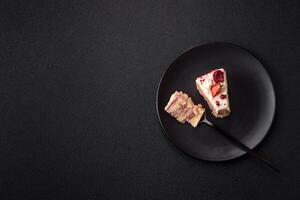 Piece of sweet layer cake with white cream, raspberries and strawberries photo