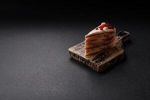 Piece of sweet layer cake with white cream, raspberries and strawberries photo