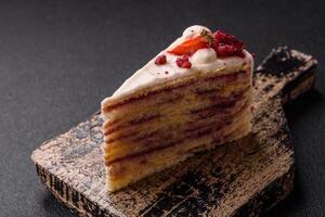 Piece of sweet layer cake with white cream, raspberries and strawberries photo