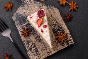 Piece of sweet layer cake with white cream, raspberries and strawberries photo