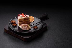 Piece of sweet layer cake with white cream, raspberries and strawberries photo