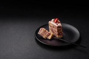 Piece of sweet layer cake with white cream, raspberries and strawberries photo