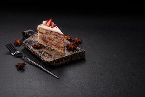 Piece of sweet layer cake with white cream, raspberries and strawberries photo
