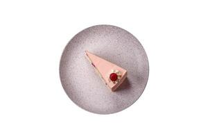 Piece of sweet cake with pink cream with raspberry flavor, with shortbread, cheesecake photo