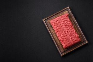 Raw ground beef or pork with salt, spices, herbs and tomatoes photo