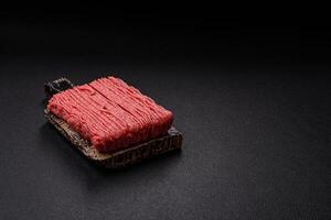 Raw ground beef or pork with salt, spices, herbs and tomatoes photo