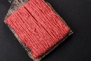 Raw ground beef or pork with salt, spices, herbs and tomatoes photo