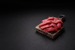 Juicy raw beef cut into slices with salt and spices photo