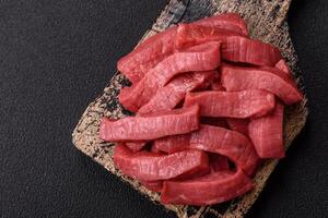 Juicy raw beef cut into slices with salt and spices photo