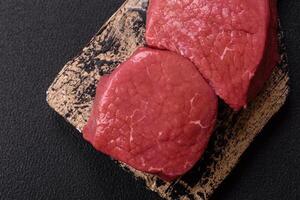 Raw beef eye steak round with salt, spices and herbs photo