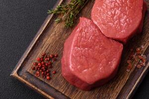 Raw beef eye steak round with salt, spices and herbs photo