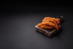 Hot crispy shrimp breaded with salt and spices with white sauce photo
