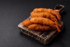Hot crispy shrimp breaded with salt and spices with white sauce photo
