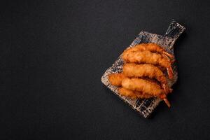 Hot crispy shrimp breaded with salt and spices with white sauce photo