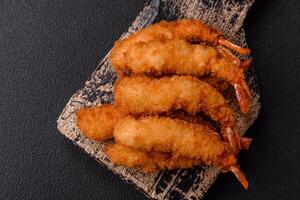 Hot crispy shrimp breaded with salt and spices with white sauce photo