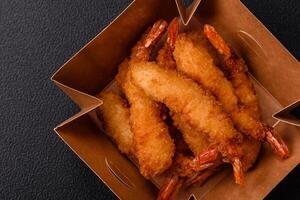 Hot crispy shrimp breaded with salt and spices with white sauce photo