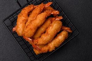 Hot crispy shrimp breaded with salt and spices with white sauce photo