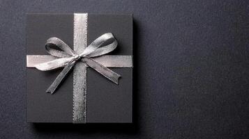 Black recycled price card with silver elastic band on a black background. photo