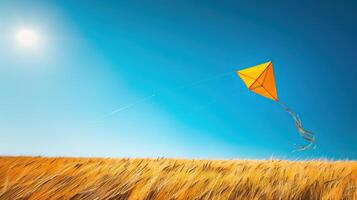 A yellow and blue kite flying high against a clear blue sky photo