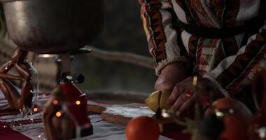 Hands slicing lemon on wooden cutting board. Cooking in Christmas time. Woman cut fresh lemon citrus fruit and put into pot. Blurry blinking lights on foreground. Low key, moving to defocus bokeh video