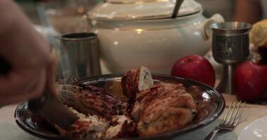 POV hands serve and cut stuffed turkey roll using knife and two prong fork on Thanksgiving dinner table with vintage crockery. Traditional Thanksgiving turkey roulade roasted on grill. Serving dinner video