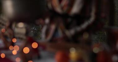 Abstract bokeh Christmas lights background and moving from defocus into focus on hand put knife on cutting board before cooking holiday food. Cooking in Christmas time. Blurry blinking lights, low key video
