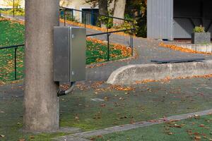 Metal utility box attached to pole in a park during autumn photo