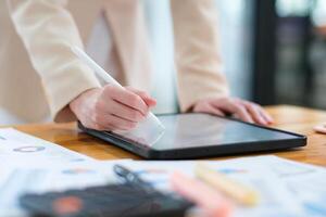 Close-up of hand signing electronic documents on a tablet with a digital pen for online workflows photo
