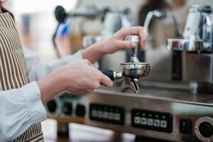 Barista tamping espresso grounds, showcasing precision and professionalism in a cafe setting. photo