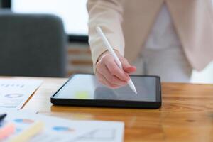 Close-up of hand signing electronic documents on a tablet with a digital pen for online workflows photo